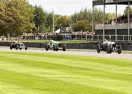 Three vintage race cars race along